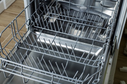 Empty dish racks inside of a dishwasher.