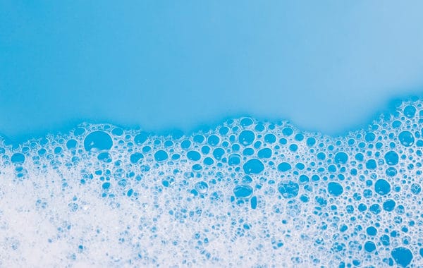 Suds from a dishwasher against a blue background