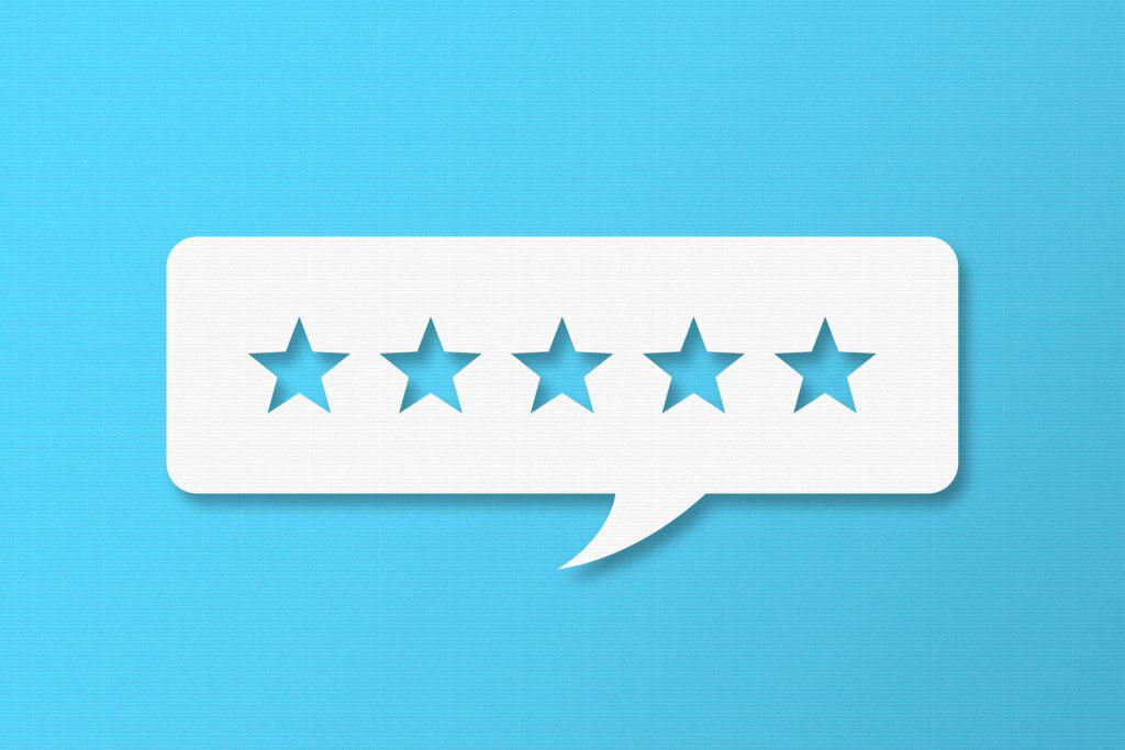 Feedback Concept - White Chat Bubble With Cut Out Star Shapes On Blue Cardboard Background