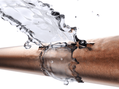 A frozen pipe bursts and sprays water/