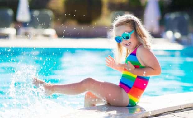 Child playing by a pool in their back yard