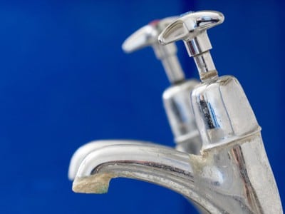 A bathroom faucet with mineral scale from hard water.