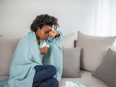 A woman with mold-related illness rests on her couch.