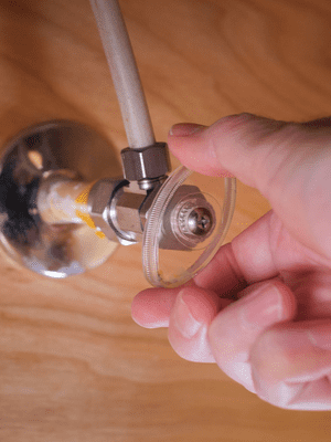 A water shut off valve under a sink.