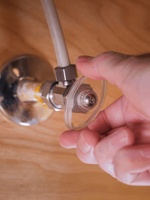 A homeowner shuts off the water to fix a leaky faucet.