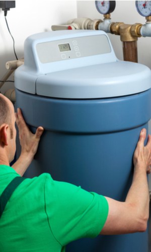 A plumbing technician installing a new water softener.