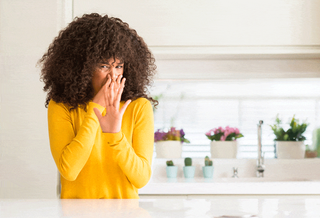 girl holding nose in kitchen | gas leak repair dallas tx frisco tx
