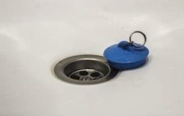 Bathtub drain with a rubber stopper next to it