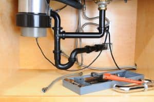 garbage disposal and tools under a sink