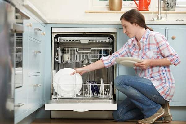 Woman putting dishes into her dishwasher