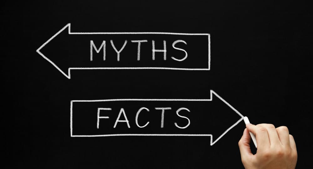 Hand sketching Myths or Facts concept with white chalk on blackboard.