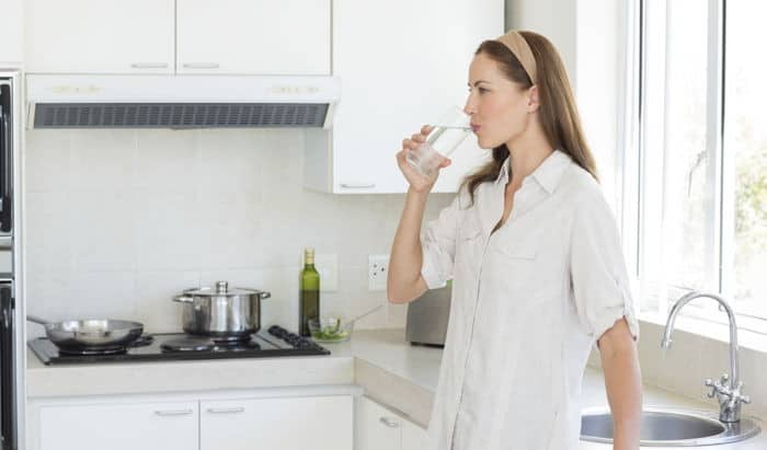 A woman takes a drink of water.