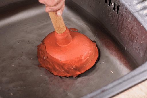 Cup plunger used to clear kitchen sink clog