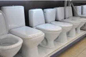 Several different types of possible replacement toilets lined up at a store