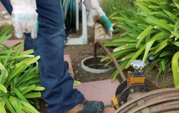 plumbing using an auger to clean out a home sewer